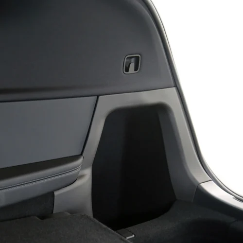 Interior of a car trunk/boot with a small recessed latch on the side panel for folding seats or trunk access