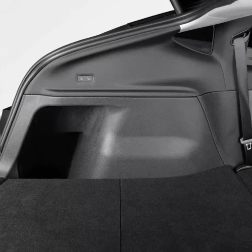 Small button with seat icons on the side panel of a car trunk, used to fold the rear seats.