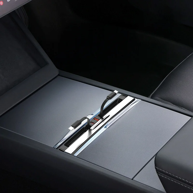 Center console of a car with a sliding tray, showing two USB-C charging ports and connected cables.