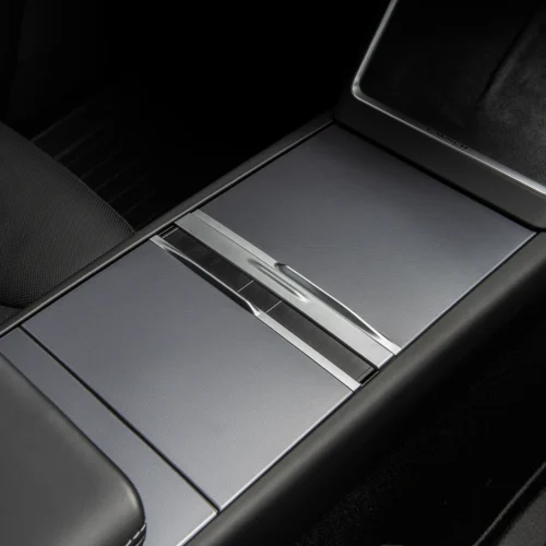 Center console of a car with brushed metal panels and a sliding cover, part of a luxury interior
