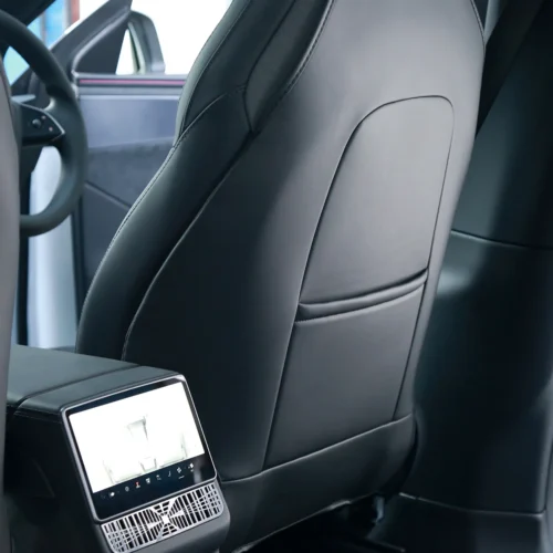 Rear view of a car's front seat and center console with a touchscreen panel and air vents.