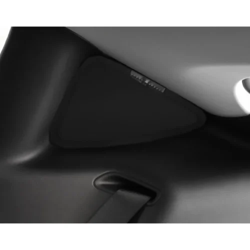 Close-up of a car seat interior showing a black triangular panel and a strap threaded through a slot.