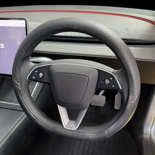 Tesla steering wheel with stitched grip and side control buttons in a modern car interior