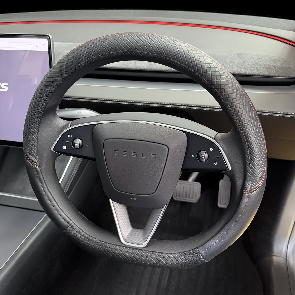Tesla steering wheel with stitched grip and side control buttons in a modern car interior