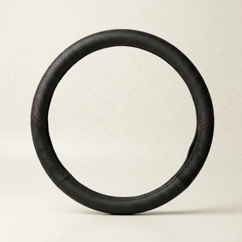 Black leather car steering wheel with red stitching on a light background.