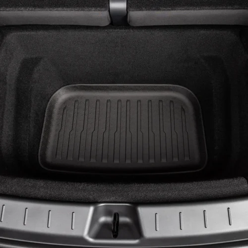 Car trunk cargo area with a ribbed black rubber mat in the center of the floor