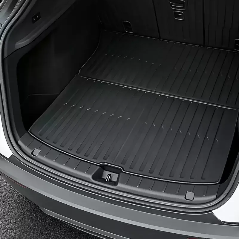 Rear cargo area of an SUV with a large black, ridged all-weather mat covering the floor.