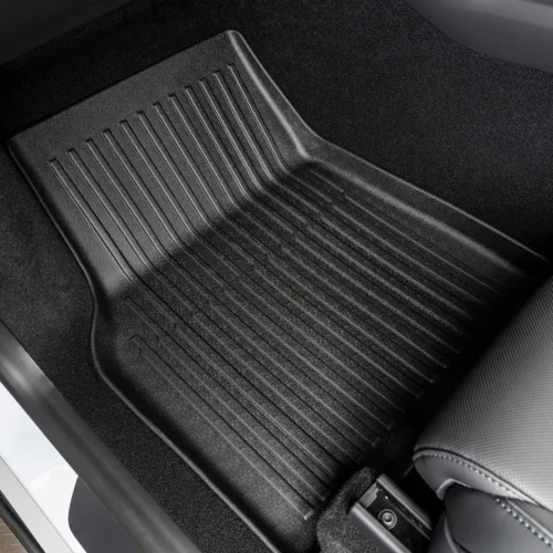 Black rubber car floor mat with raised ridges in the driver’s footwell.