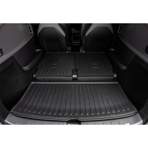 SUV rear cargo area with folded rear seats creating a flat loading floor and ribbed rubber matting Full-width view from the back of the vehicle
