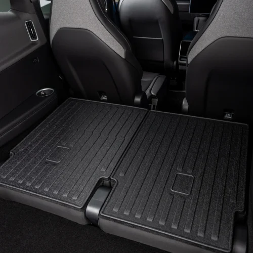 Rear seats folded flat to create a large cargo loading area in a dark SUV/vehicle interior.