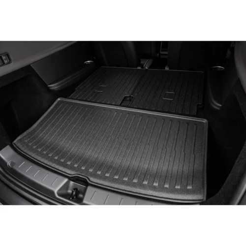 Dark, ridged rubber cargo mat laid in an SUV trunk with the rear seats folded down for extra cargo space