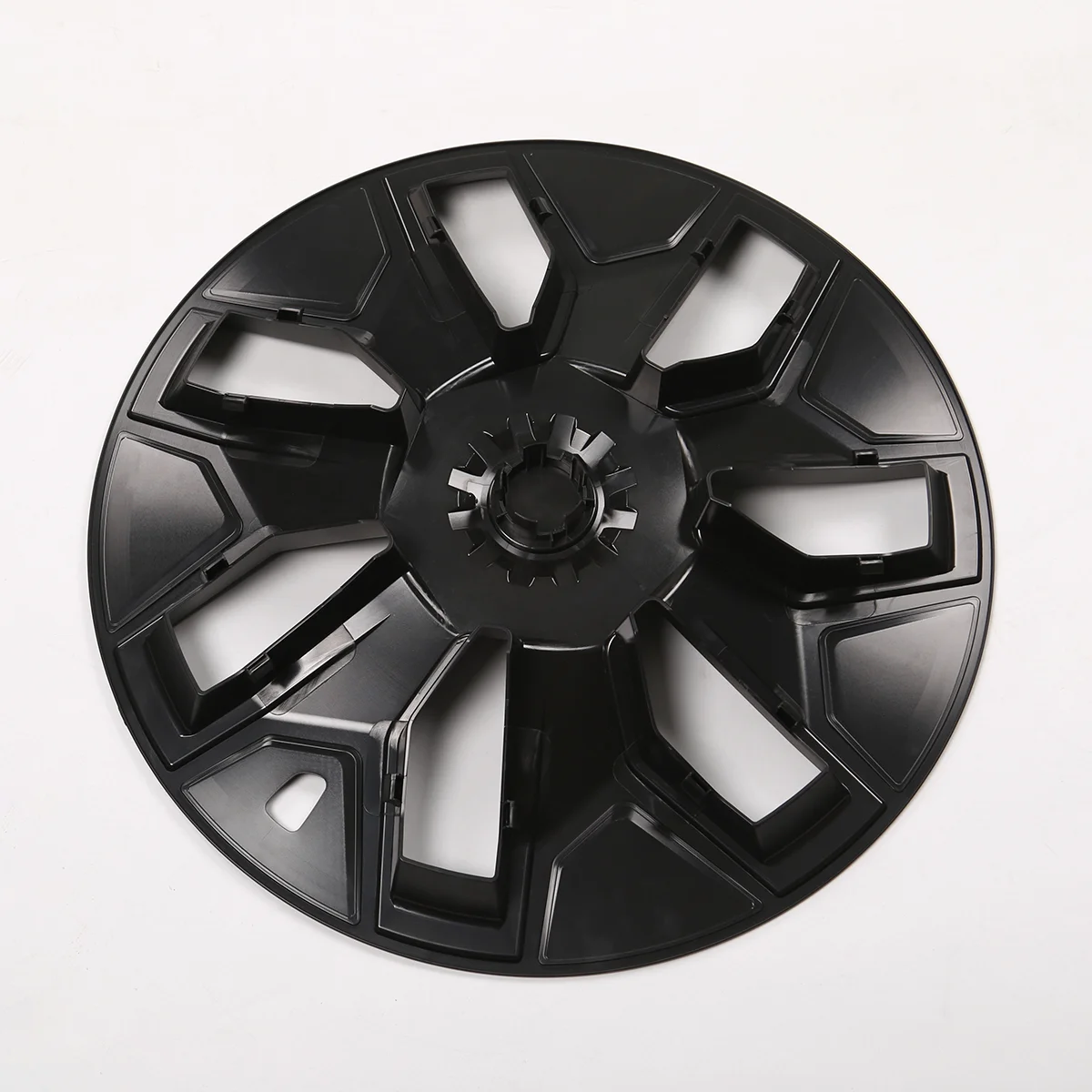 Large black plastic circular component with eight spokes and central gear, placed on a white surface.